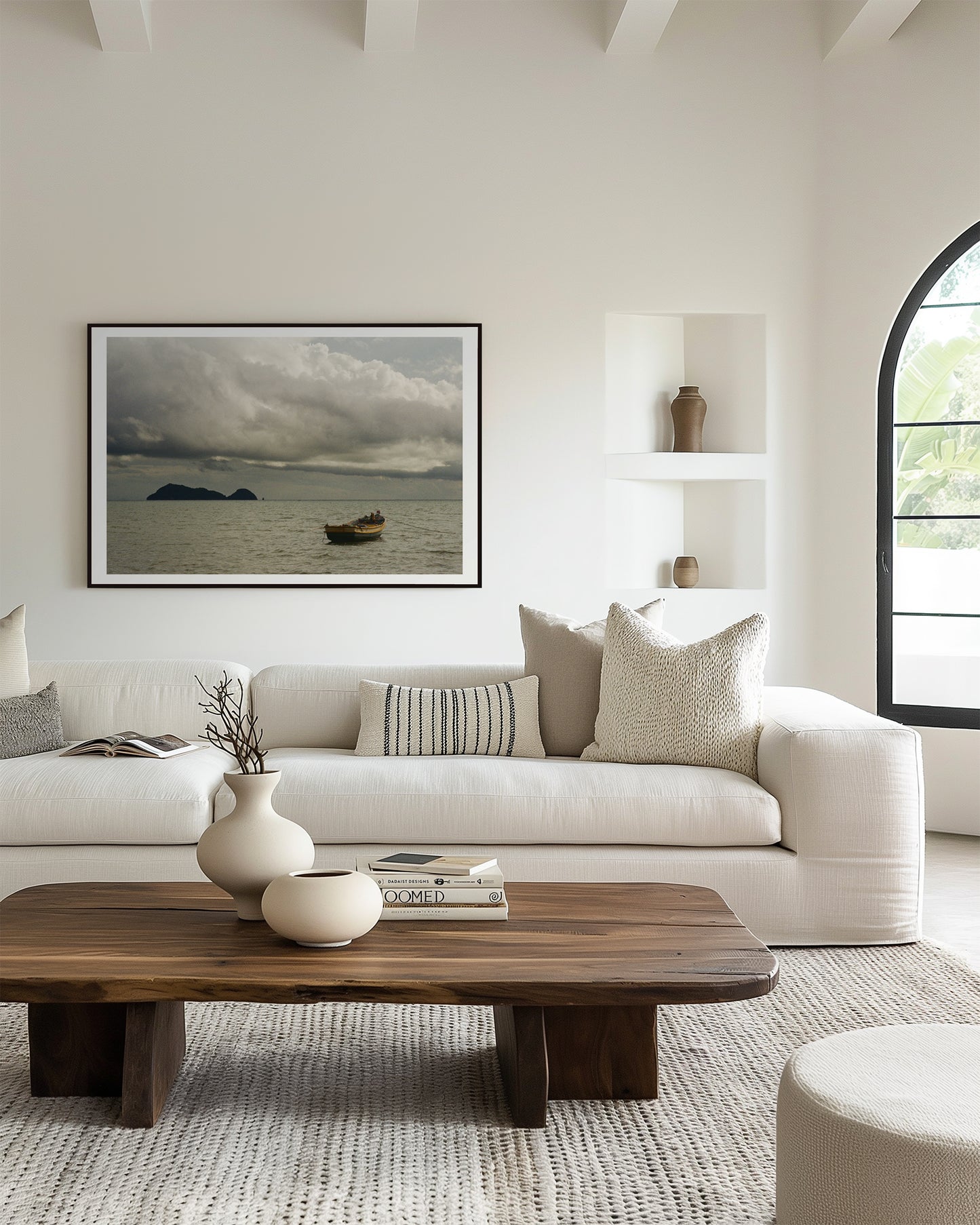 Modern living room with a white sofa, wooden coffee table, and framed artwork on the wall.