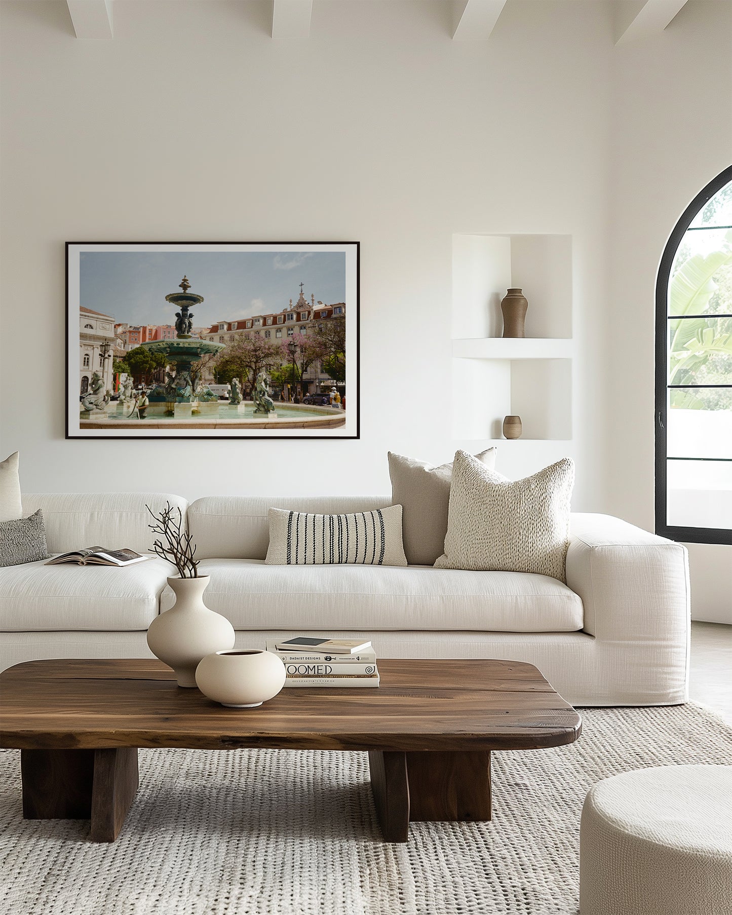 Modern living room with a white sofa, wooden coffee table, and framed artwork on the wall.