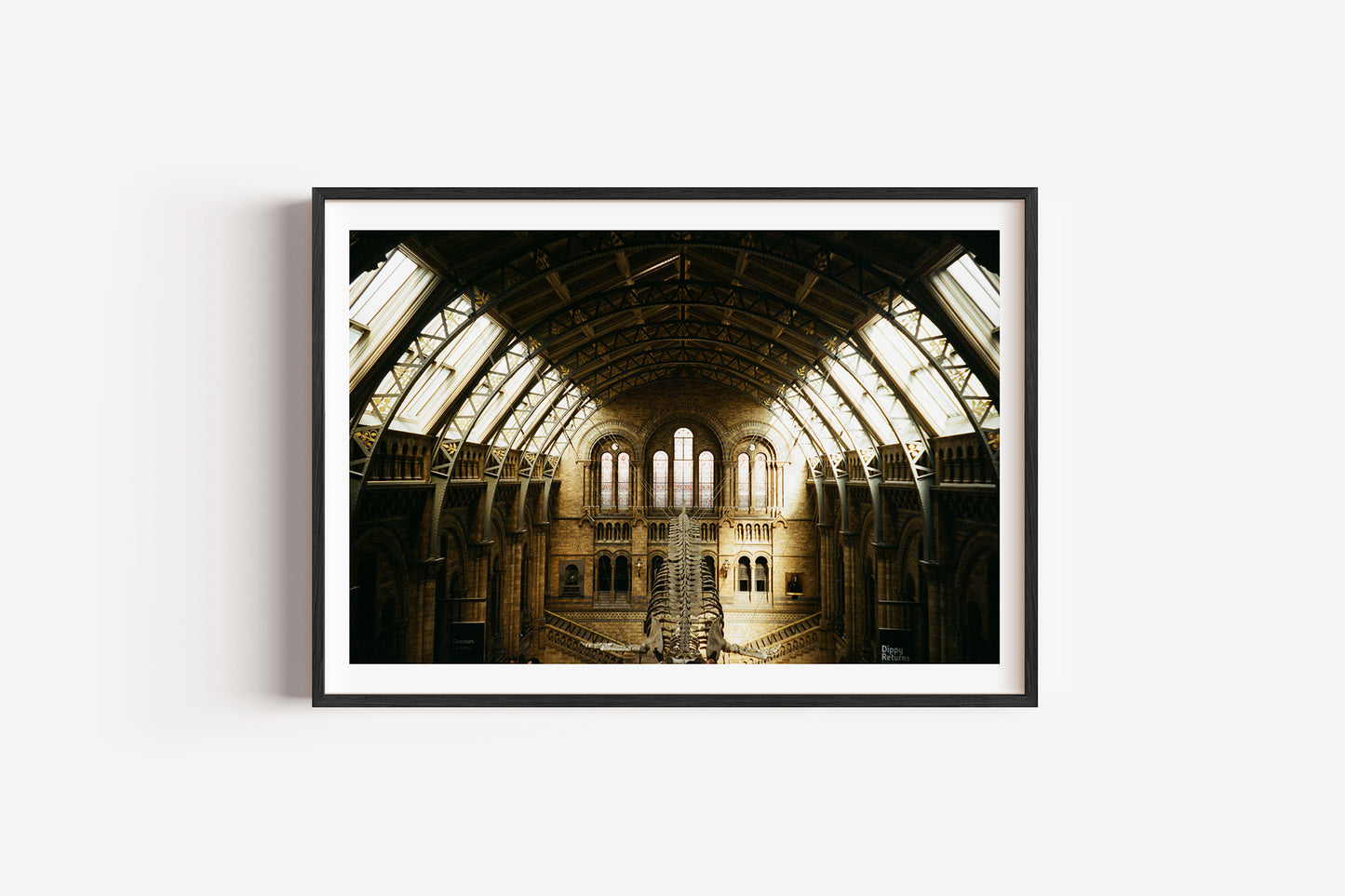 Framed photograph of a large, open architectural space with high ceilings and large windows.