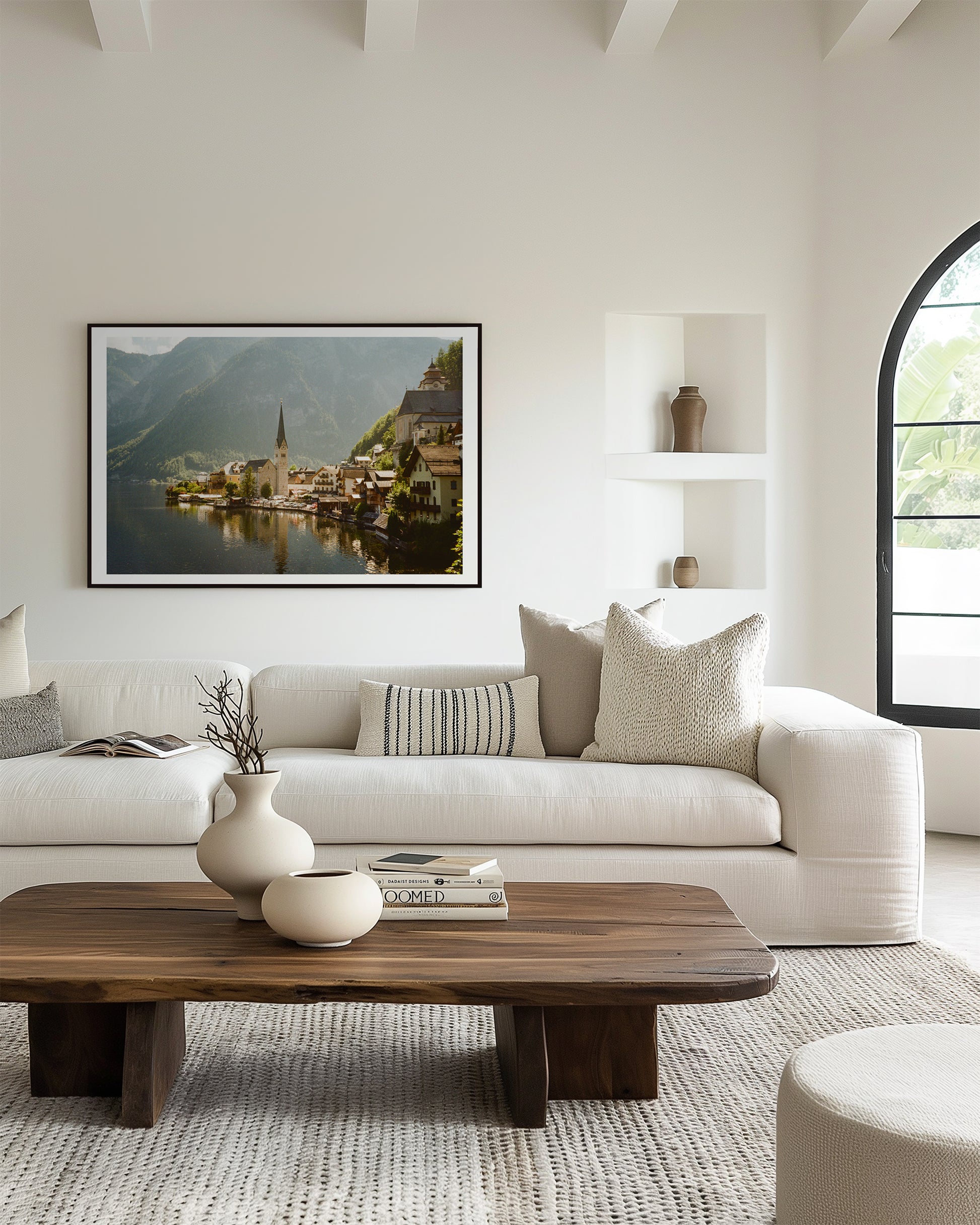 Modern living room with a white sofa, wooden coffee table, and scenic wall art.