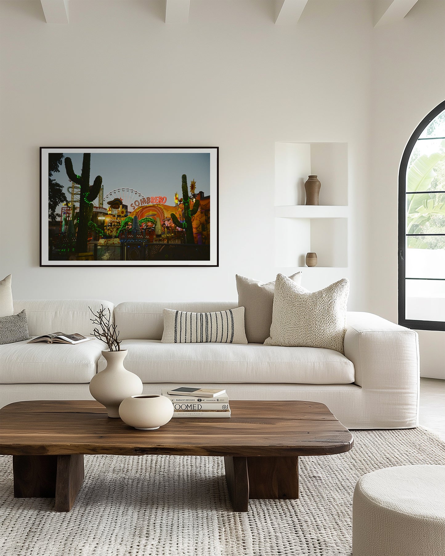 Modern living room with a white sofa, wooden coffee table, and artwork on the wall.